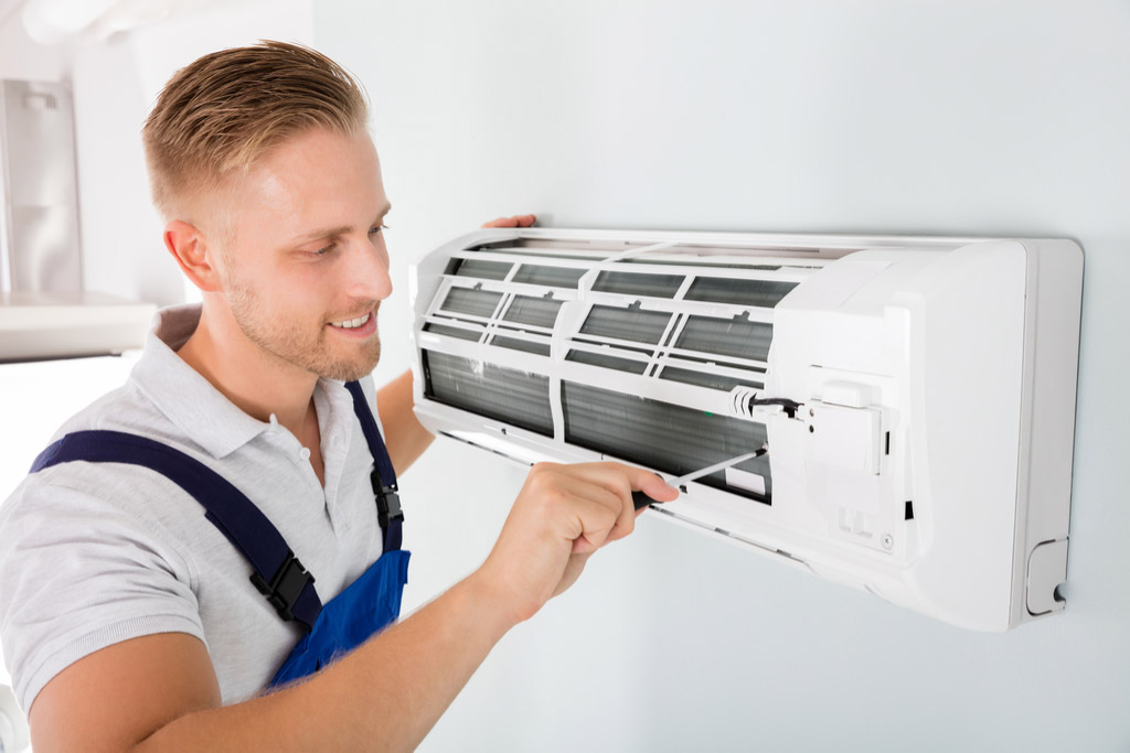 HVAC technician performing ductless air conditioning maintenance in Buckeye