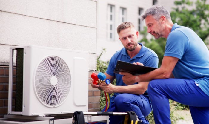 HVAC technicians installing an outdoor air conditioning unit in Buckeye