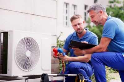 ac-installation-in-claremont-ca HVAC technicians reviewing an outdoor air conditioning unit in Buckeye, AZ