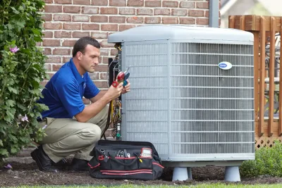 design-air-heating-and-air-conditioning-decatur-il-05 – Copy HVAC technician inspecting an outdoor air conditioning unit in Buckeye, AZ